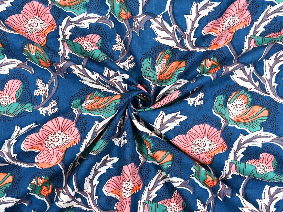 Deep navy cotton fabric showing pink and coral poppy blooms with green foliage