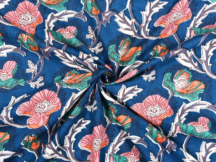 Deep navy cotton fabric showing pink and coral poppy blooms with green foliage