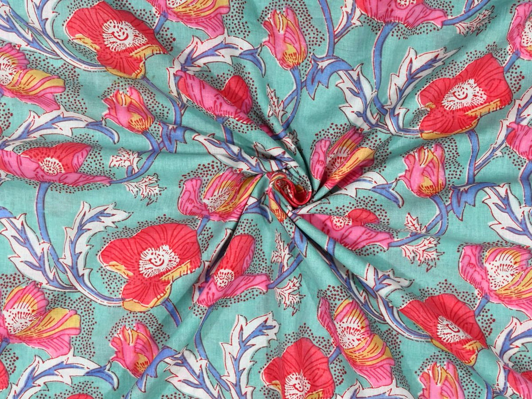 Mint cotton fabric showing hot pink and coral poppy blooms with yellow centers