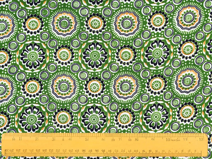 Close-up of green geometric cotton fabric with detailed linework and dotted details