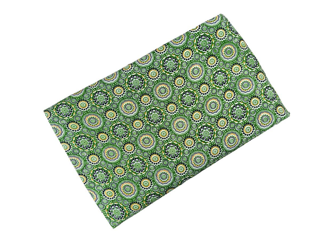 Dense geometric block print fabric with sunburst rosettes on green ground