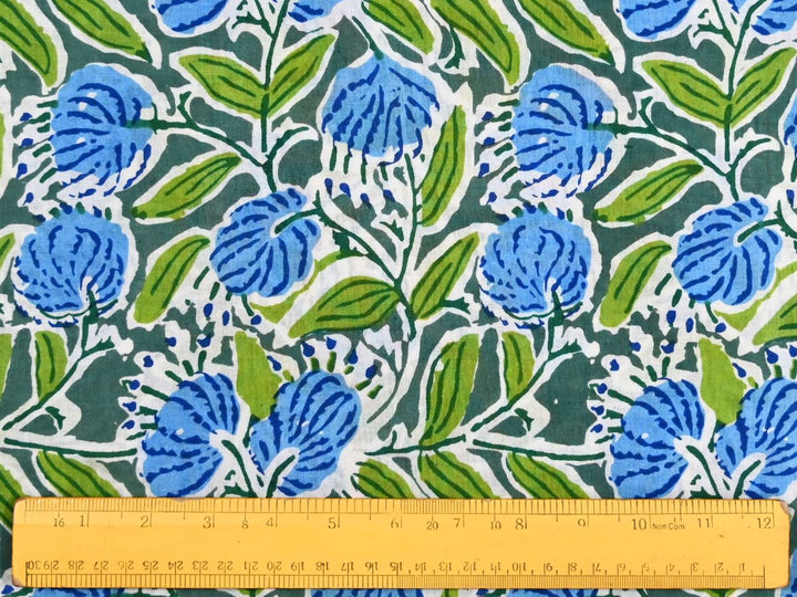Close-up of blue green floral cotton fabric with detailed linework and leafy stems