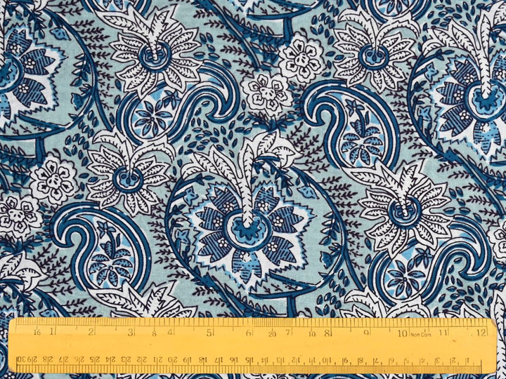 Close-up of blue paisley cotton fabric with detailed linework and dotted accents