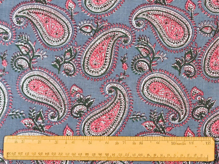 Close-up of pink paisley cotton fabric with detailed linework and small bud motifs