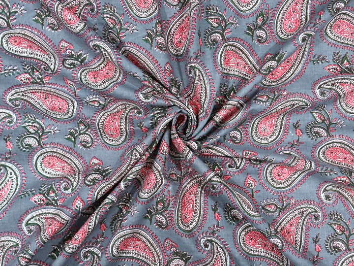 Grey-blue cotton fabric showing pink and coral paisley motifs with white details