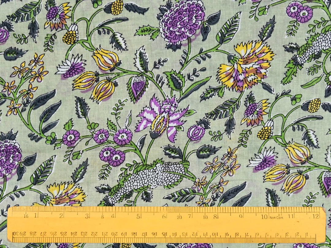 Close-up of sage green floral cotton fabric with detailed linework and bud accents