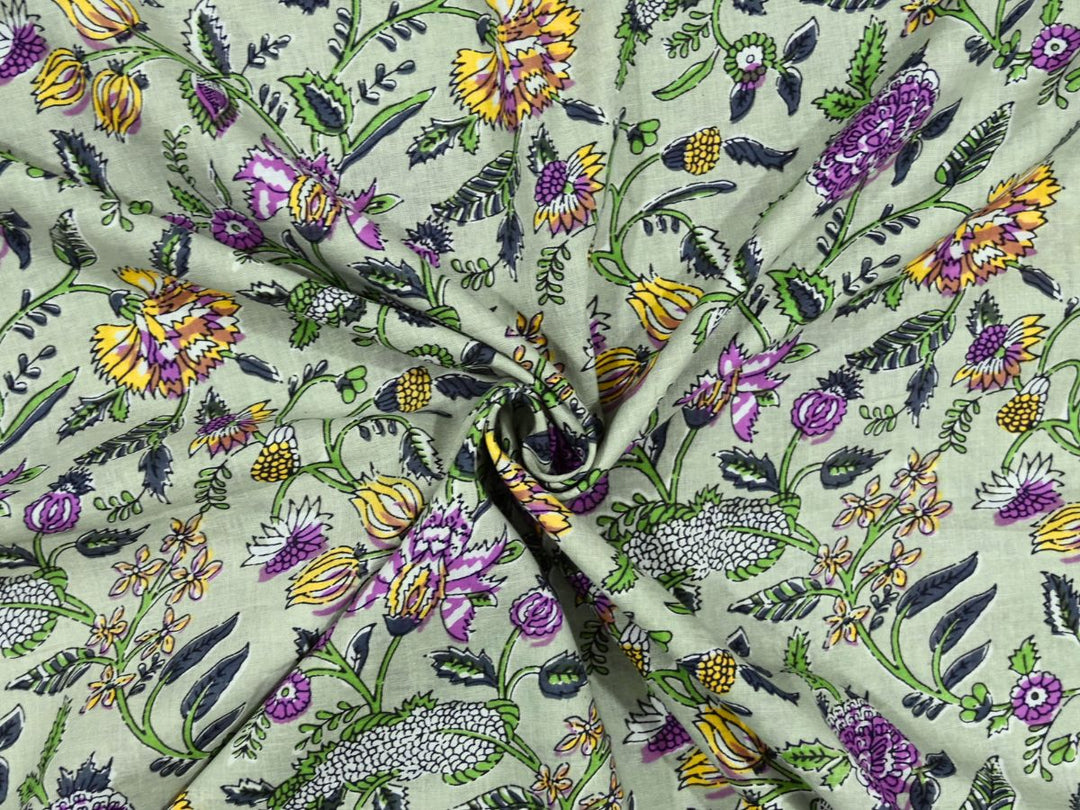 Sage green cotton fabric showing purple marigolds and yellow coneflowers