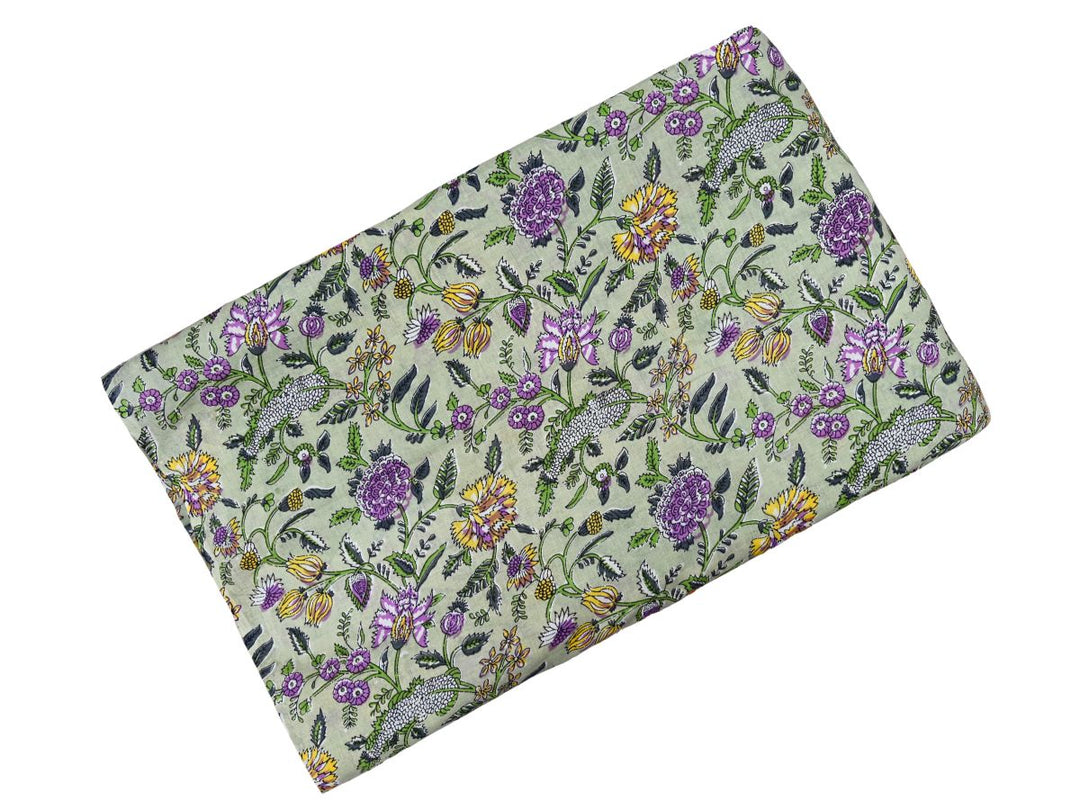 Dense floral block print fabric with white sprigs and green leafy vines