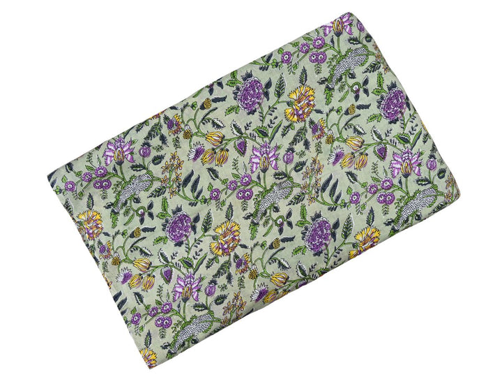 Dense floral block print fabric with white sprigs and green leafy vines