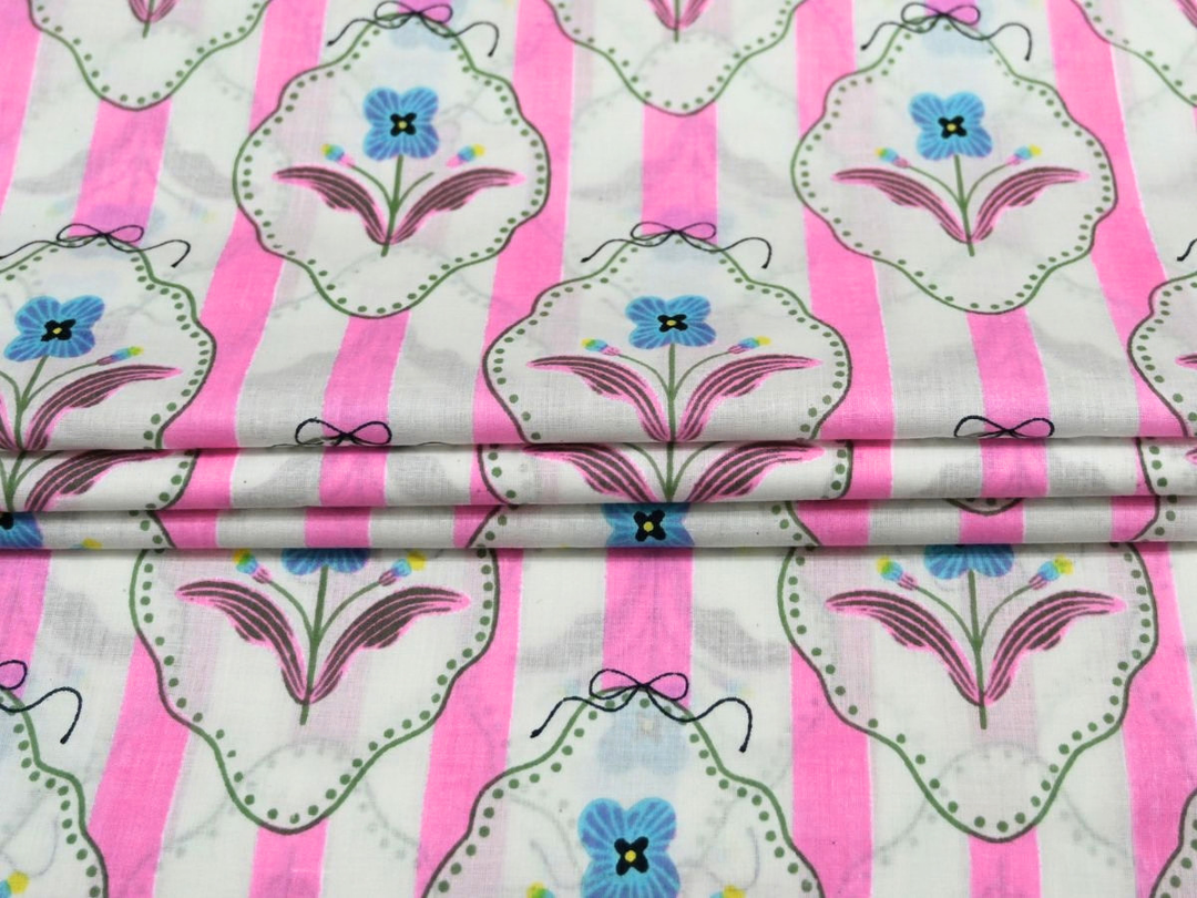 Close-up of pink stripe cotton fabric with blue flower motifs in decorative frames