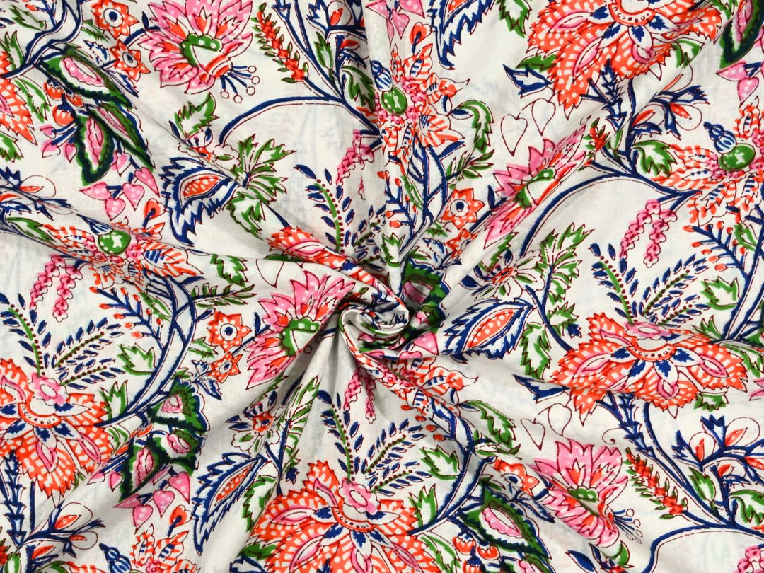 White cotton fabric showing coral blooms with pink lotus flowers and navy foliage