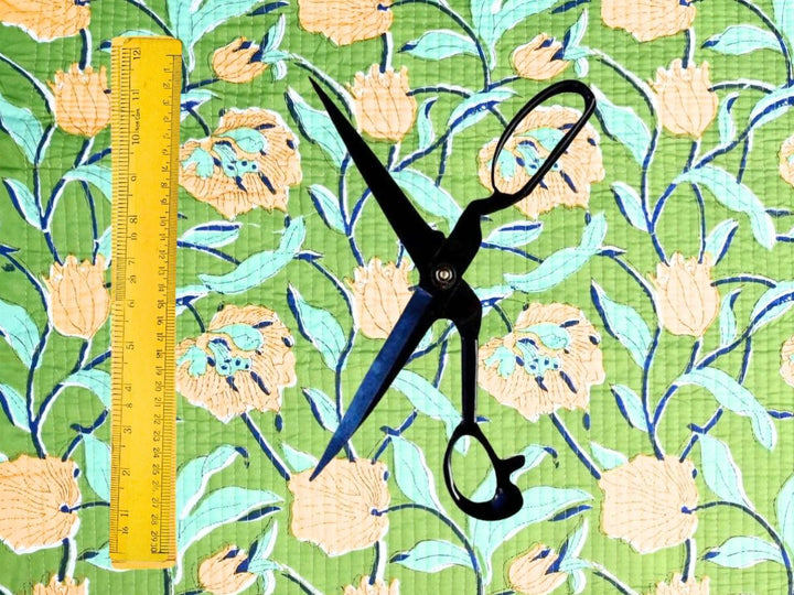 Green floral quilted cotton fabric showing quilting stitch lines
