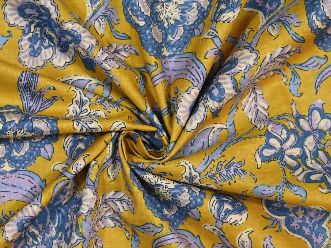 Yellow cotton fabric showing blue and lavender flowers with white centers