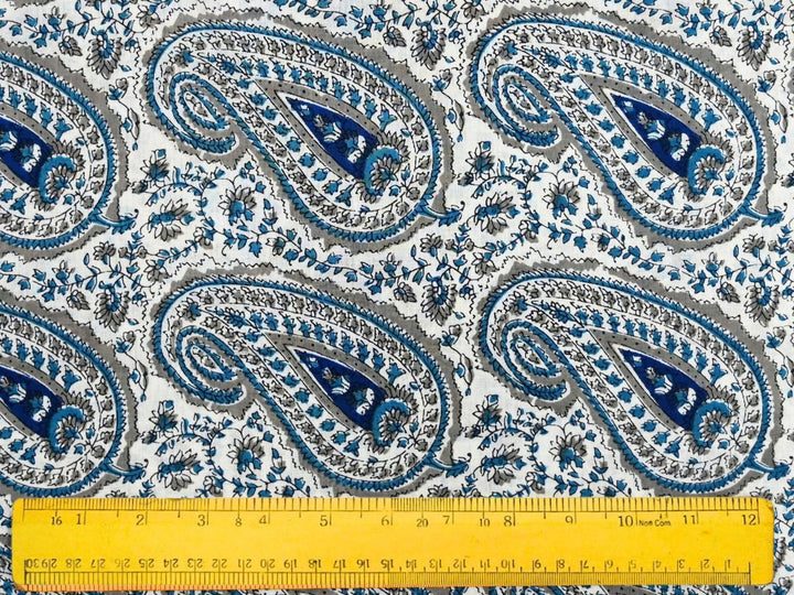 Close-up of paisley cotton fabric with navy and teal accents and small floral details