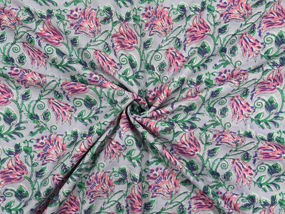 Light lavender cotton fabric showing striped pink blooms with green foliage