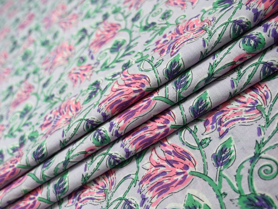 Light lavender cotton fabric showing striped pink blooms with green foliage