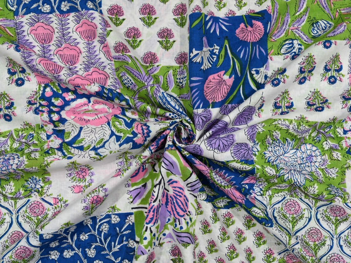 White cotton fabric showing pink, green, navy, and purple block motifs