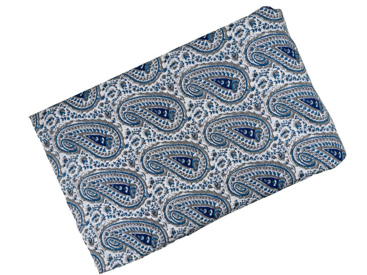 White cotton fabric showing navy blue paisley motifs with teal leafy vines