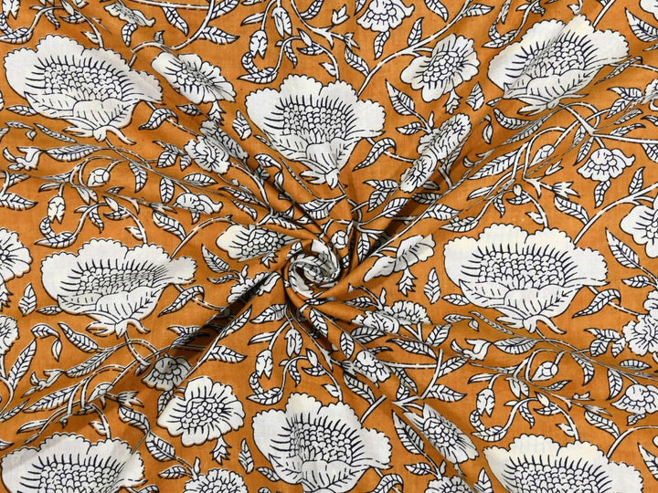Mustard cotton fabric showing chrysanthemum-style white flowers and vines