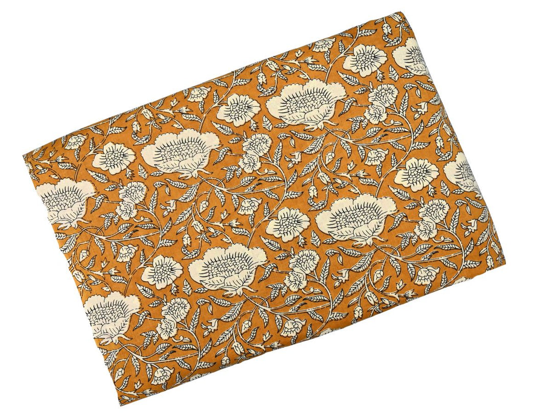 Close-up of mustard floral cotton fabric with leafy vines and bud accents