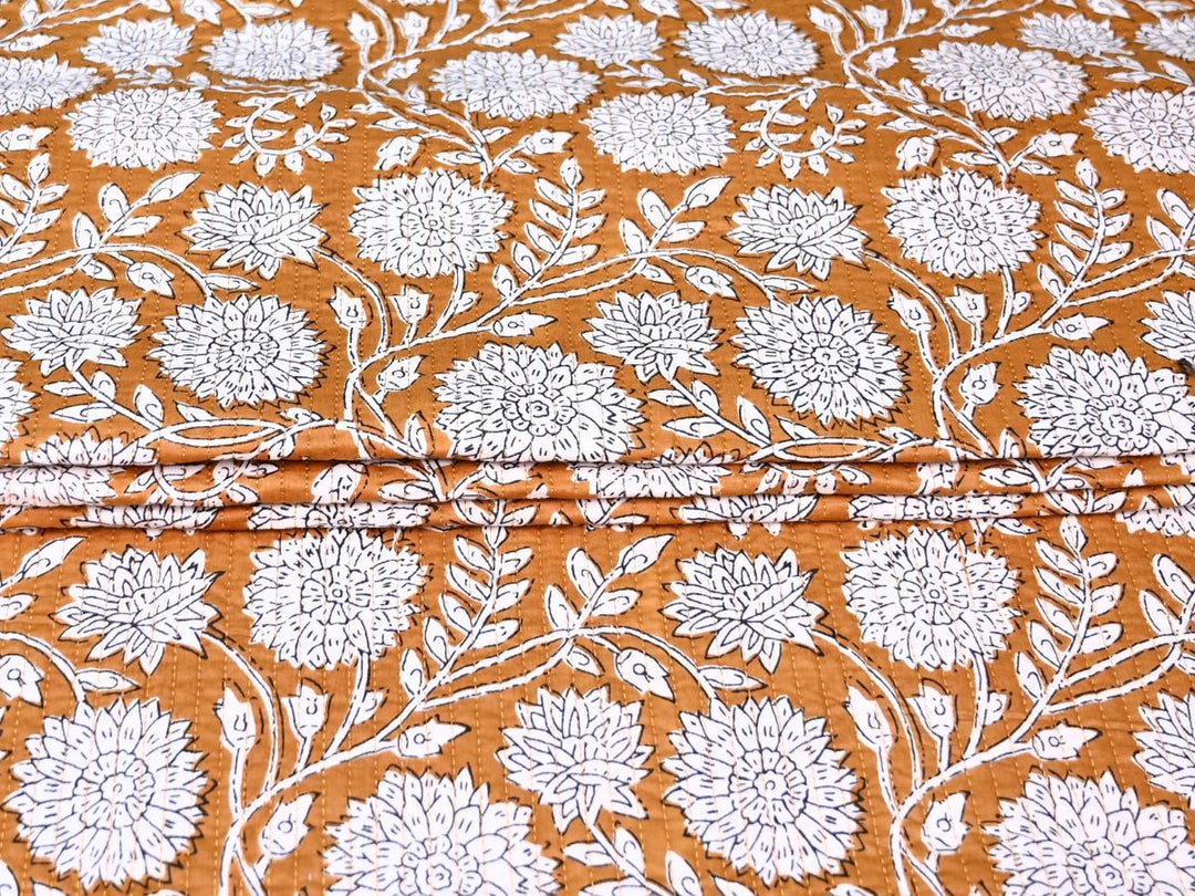 Reversible quilted fabric with orange and white striped reverse