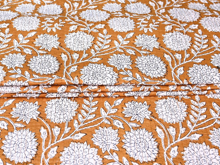 Reversible quilted fabric with orange and white striped reverse