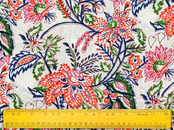 Close-up of orange floral cotton fabric with detailed linework and heart-shaped motifs