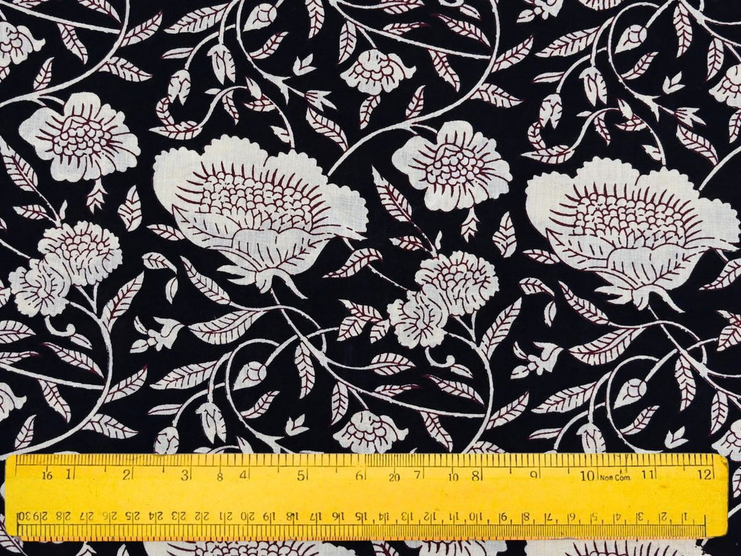 Close-up of black floral cotton fabric with leafy vines and bud accents