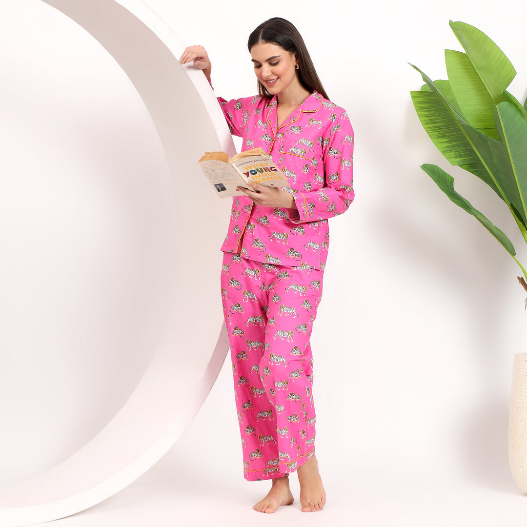 Leaning view of pink cotton pajama set with tiger print and lapel collar, designed for ultimate comfort and style.