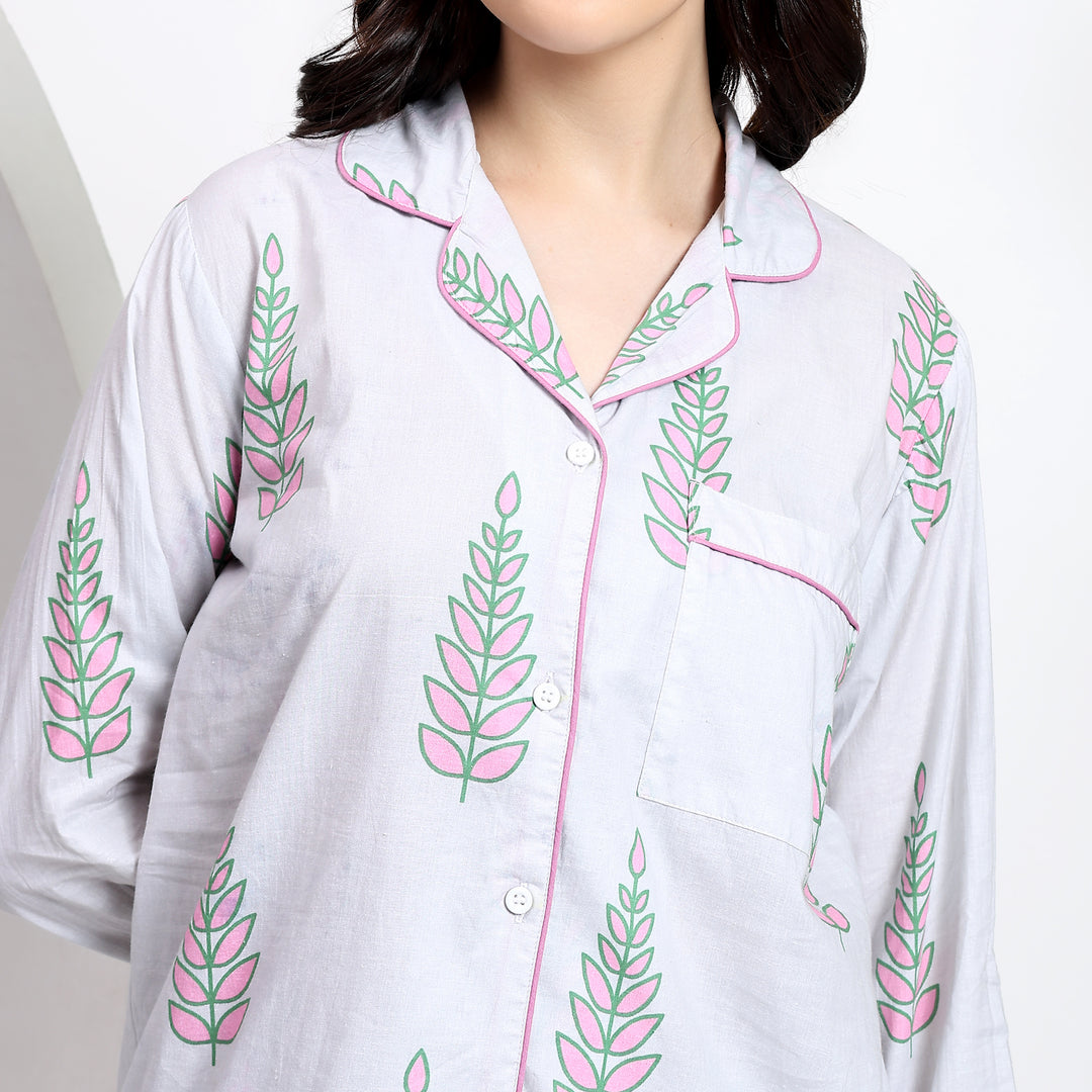 Close-up of white cotton pj set with lapel collar and floral print, showcasing the front pocket detail.