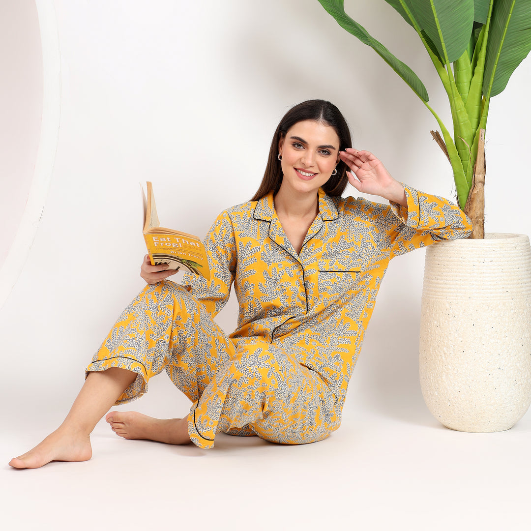 Yellow floral Long PJ Set styled while leaning against a pot, showcasing relaxed elegance.