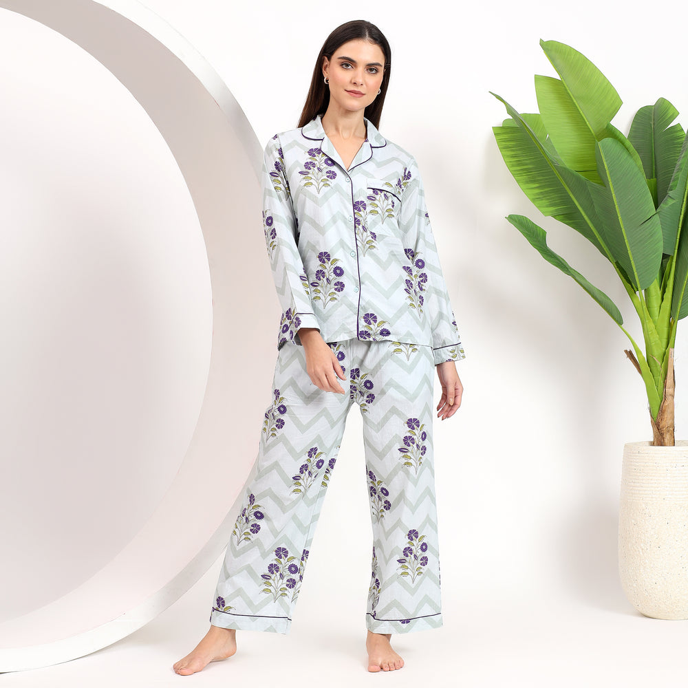 Front view of off-white cotton pajama set with lavender floral handblock print, featuring a lapel collar and front pocket.