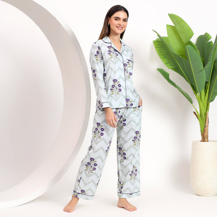 Styling view of off-white cotton pajama set with lavender floral print, featuring lapel collar and side pockets for extra comfort.